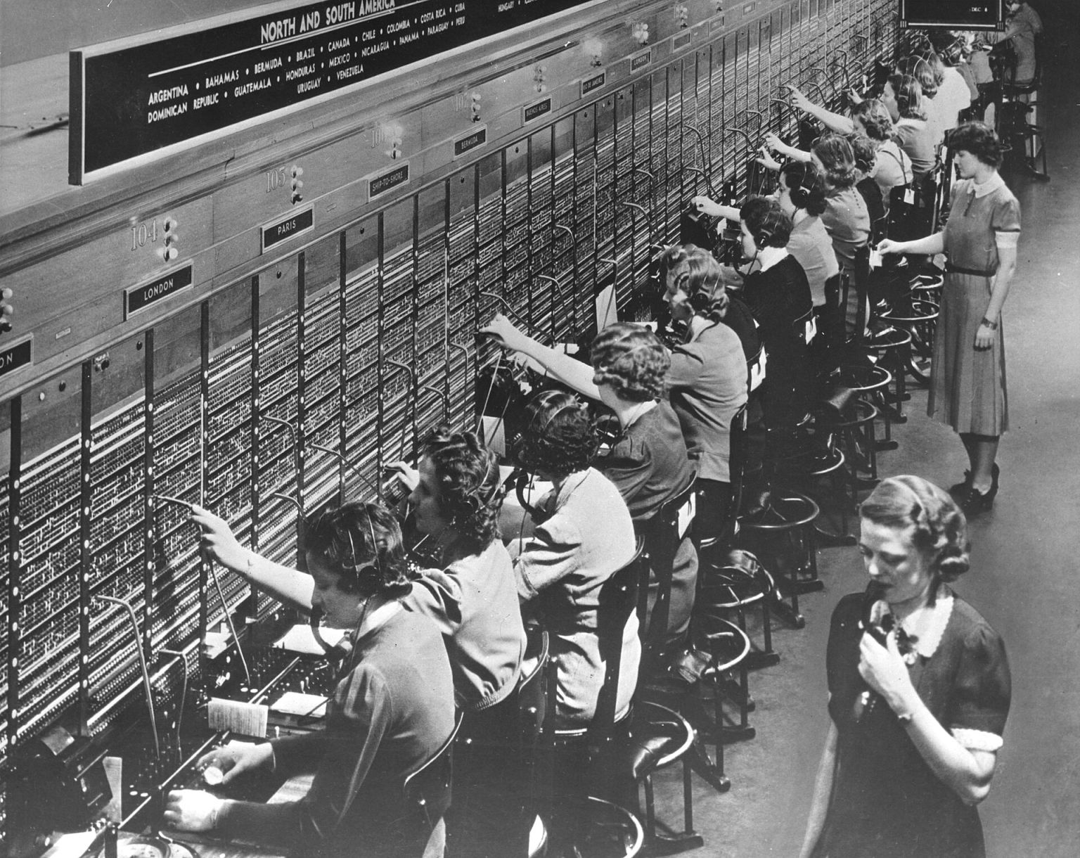 Телефонистки за коммутатором вручную соединяют линии штекерами